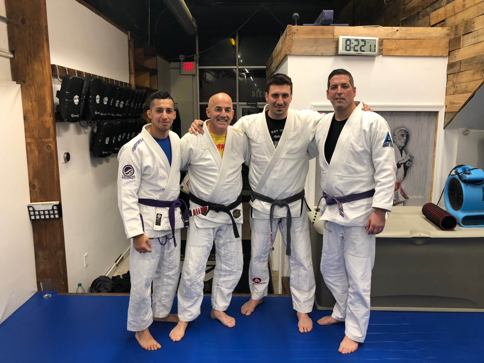 Ivan Perez with coaches and training partners in their gis on the academy mats