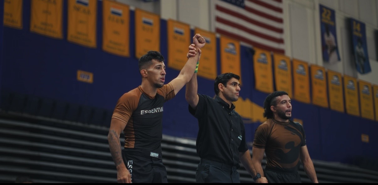 Referee raising a Pressure grappler's hand after a submission-only match win